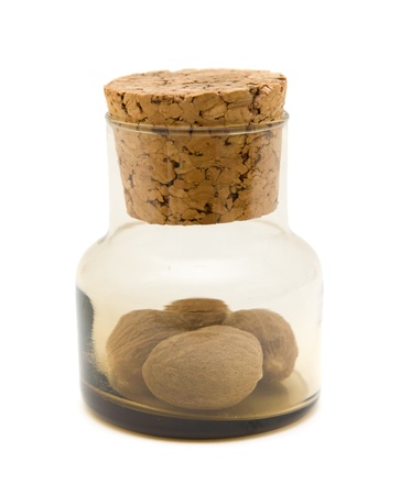 small brown glass bottle with nutmeg inside, isolated on whiteの写真素材
