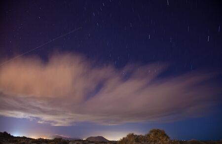 Long exposure shot of stars over dunes of Corralejo, Top of Isla de Lobos visible