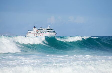 Sea swell and ferry - ARMAS ferry going from Lanzarote to Fuerteventura, large waves on the foregroundのeditorial素材