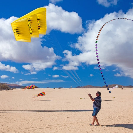 FUERTEVENTURA, SPAIN - NOVEMBER 09: Viewers watch from the ground as multicolored kites fill the sky at 25th International Kite Festival, November 9, 2012 in Dunes of Corralejo, Fuerteventura, Spainのeditorial素材