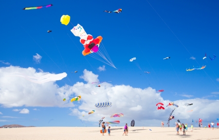 FUERTEVENTURA, SPAIN - NOVEMBER 09: Viewers watch from the ground as multicolored kites fill the sky at 25th International Kite Festival, November 9, 2012 in Dunes of Corralejo, Fuerteventura, Spainのeditorial素材