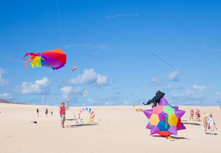 FUERTEVENTURA, SPAIN - NOVEMBER 09: Viewers watch from the ground as multicolored kites fill the sky at 25th International Kite Festival, November 9, 2012 in Dunes of Corralejo, Fuerteventura, Spainのeditorial素材