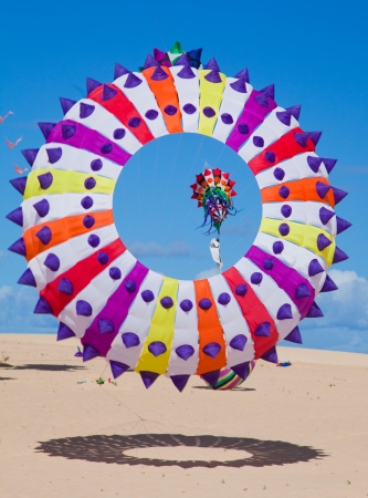 FUERTEVENTURA, SPAIN - NOVEMBER 09: Viewers watch from the ground as multicolored kites fill the sky at 25th International Kite Festival, November 9, 2012 in Dunes of Corralejo, Fuerteventura, Spainのeditorial素材
