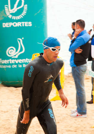CORRALEJO - April 07: Men finish  the swimming part of the race of  Fuerteventura triathlon 07 April, 2013 in Corralejo, Fuerteventura, Spainのeditorial素材