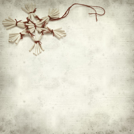 textured old paper background with traditional straw Christmas ornamentsの写真素材