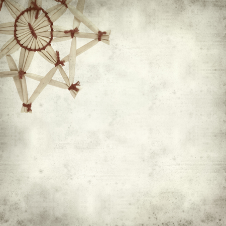 textured old paper background with traditional straw Christmas ornamentsの写真素材