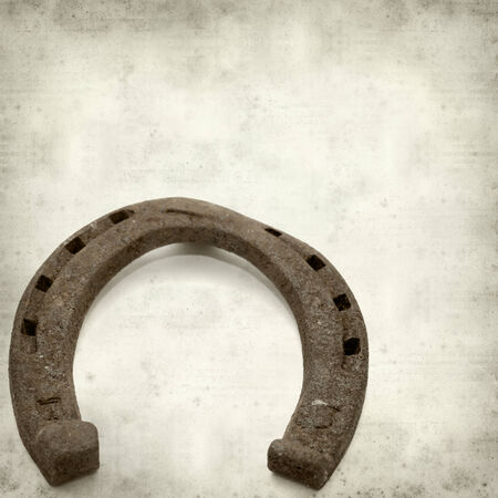 textured old paper background with rusty horseshoeの写真素材