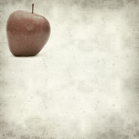 textured old paper background with red appleの写真素材