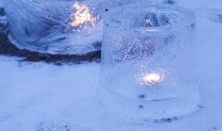 ice lanterns - lanterns made of ice from patially frozed water containers, candle inside, set outside in evening lightの写真素材