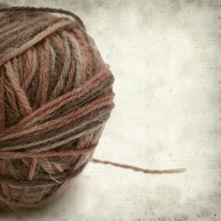 textured old paper background with knitting yarnの写真素材