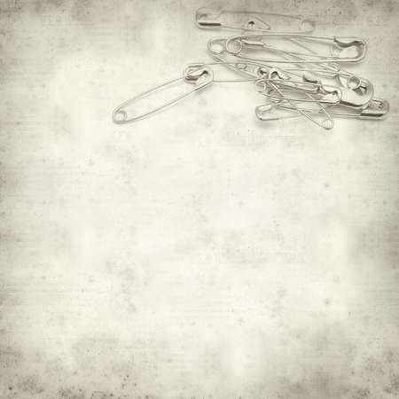 textured old paper background with safety pinの写真素材