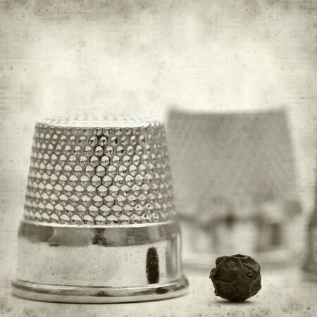 textured old paper background with thimblesの写真素材