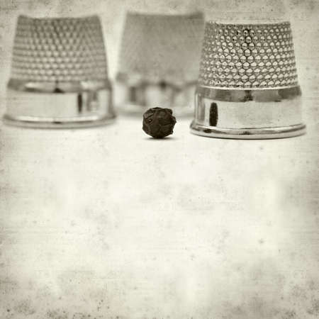 textured old paper background with thimblesの写真素材