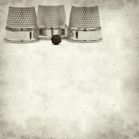 textured old paper background with thimblesの写真素材