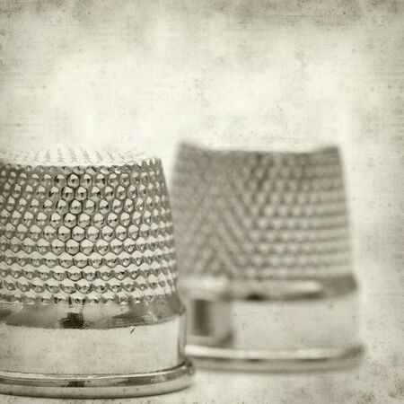 textured old paper background with thimblesの写真素材