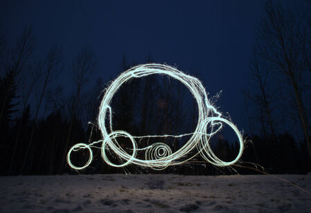 sparkler games - impossible bycicle drwn in the air by sparkler stick, wintry background
