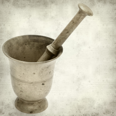 textured old paper background with copper mortar and pestleの写真素材