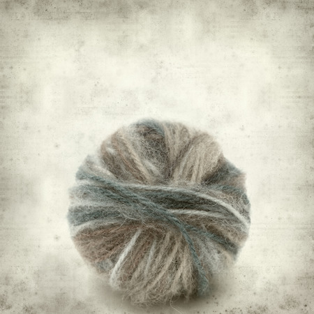 textured old paper background with knitting wool の写真素材
