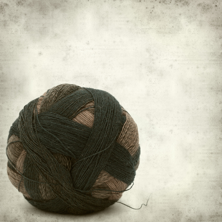 textured old paper background with knitting wool の写真素材