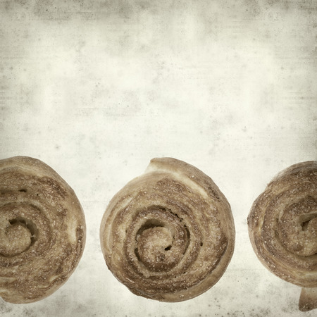 textured old paper background with scandinavian cinnamon bunの写真素材