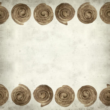 textured old paper background with scandinavian cinnamon bunの写真素材