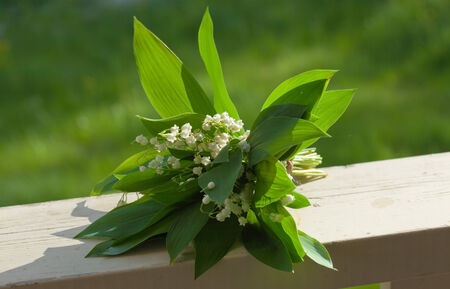 bunch of lily of the valley on a wooden railing