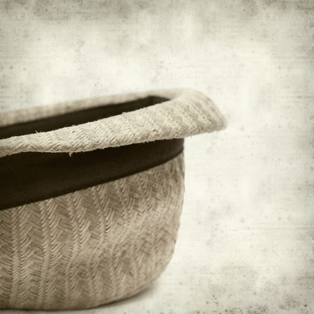 textured old paper background with old broken panama straw hatの写真素材