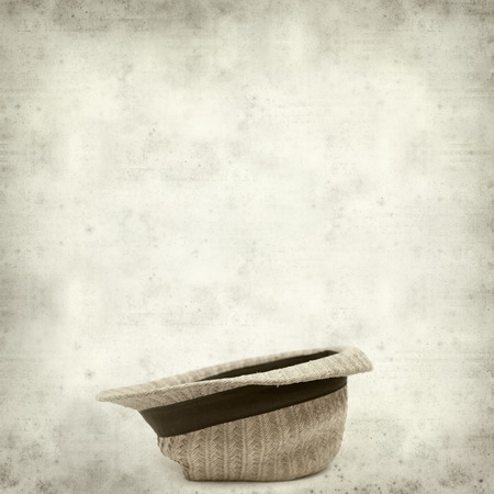 textured old paper background with old broken panama straw hatの写真素材