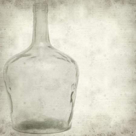 textured old paper background with old glass bottleの写真素材