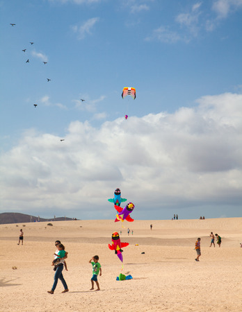 FUERTEVENTURA, SPAIN - NOVEMBER 08: Viewers watch from the ground as multicolored kites fill the sky at 27th International Kite Festival, November 08, 2014 in Dunes of Corralejo, Fuerteventura, Spainのeditorial素材
