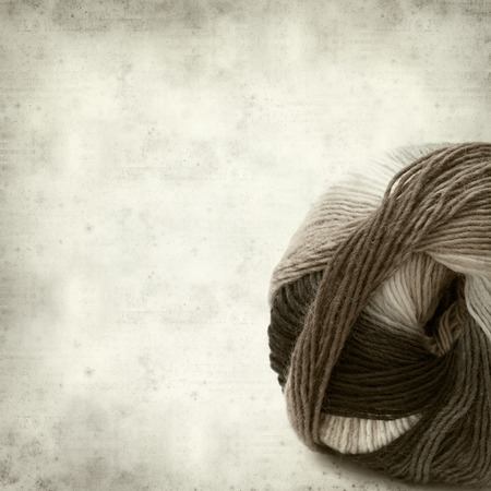 textured old paper background with knitting yarnの写真素材