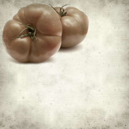 textured old paper background with large red tomatoesの写真素材