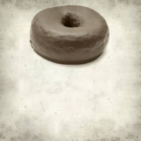 textured old paper background with chocolate glaze donutの写真素材