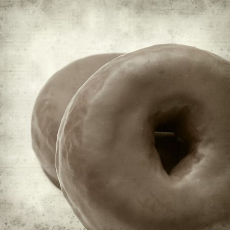 textured old paper background with chocolate glaze donutの写真素材