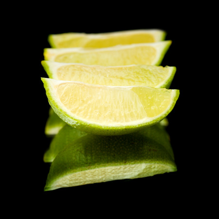 lime fruit on black mirror, isolatedの写真素材