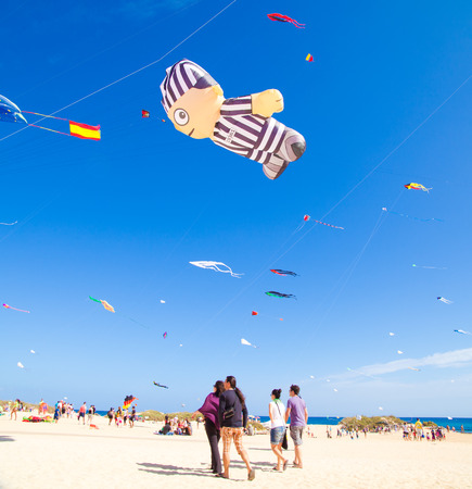 FUERTEVENTURA - NOVEMBER 13: Viewers watch from the ground as multicolored kites fill the sky at 24th International Kite Festival (Festival de Cometas), November 13, 2011 in Dunes of Corralejo, Fuerteventura, Spainのeditorial素材