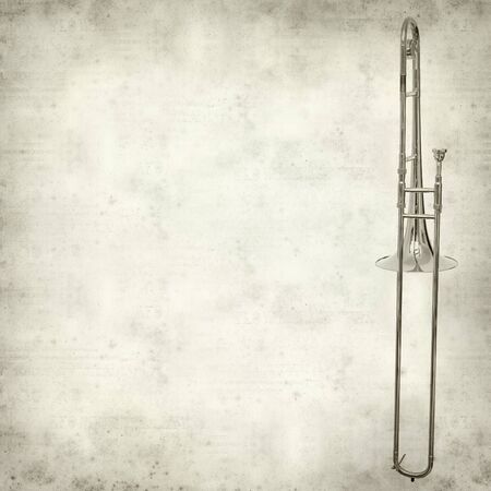 textured old paper background with silver tromboneの写真素材