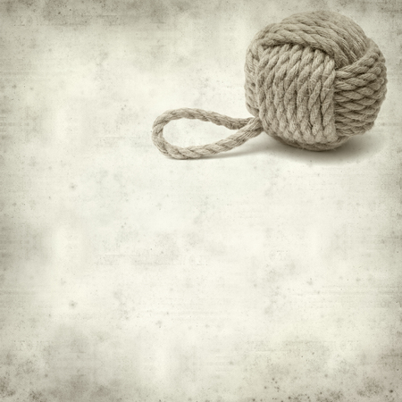 textured old paper background with monkey fist knotの写真素材