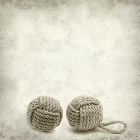 textured old paper background with monkey fist knotの写真素材