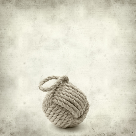 textured old paper background with monkey fist knotの写真素材