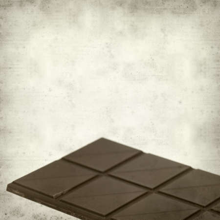 textured old paper background with dark chocolate barの写真素材