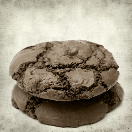 textured old paper background with dark chocolate cookiesの写真素材