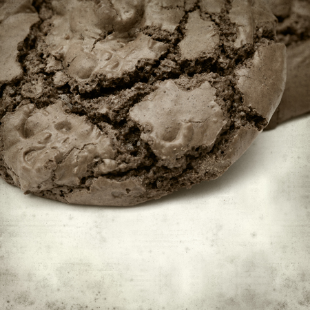 textured old paper background with dark chocolate cookiesの写真素材