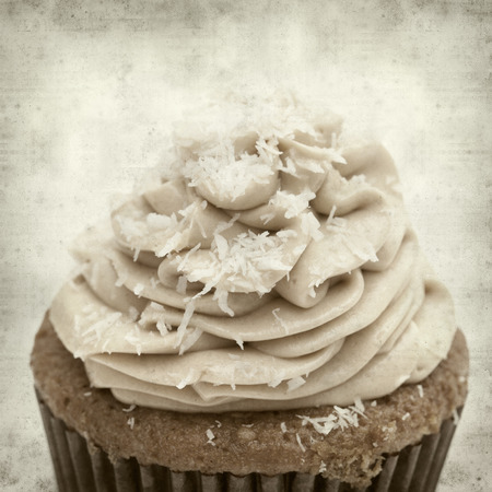 textured old paper background with cupcake with swirled icingの写真素材