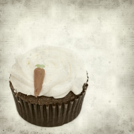 textured old paper background with cupcake with swirled icingの写真素材
