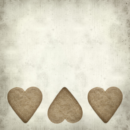textured old paper background with ginder thin cookie shaped like a heartの写真素材