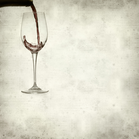 textured old paper background with pouring wineの写真素材