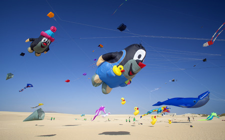 FUERTEVENTURA, SPAIN - NOVEMBER 11: Viewers watch from the ground as colorful kites fill the sky at 30th International Kite Festival, November 11, 2017 in Nature park Dunes of Corralejo, Fuerteventura, Spainのeditorial素材