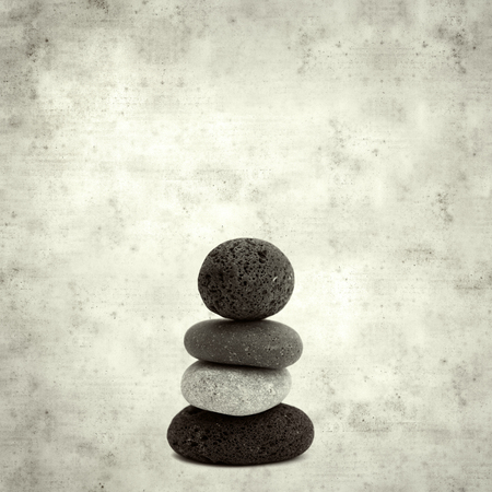 textured stylish old paper background, square, with small zen pyramid of lava pebblesの写真素材