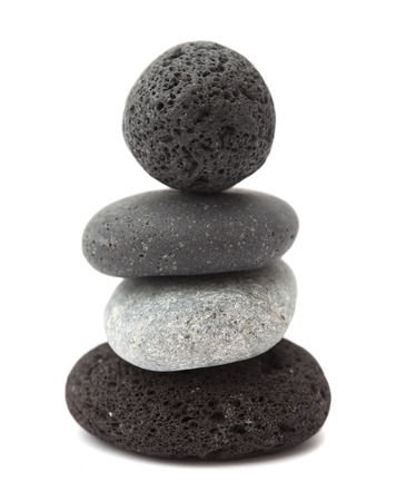 small zen pyramid of dark Canarian lava pebbles isolated on whiteの写真素材